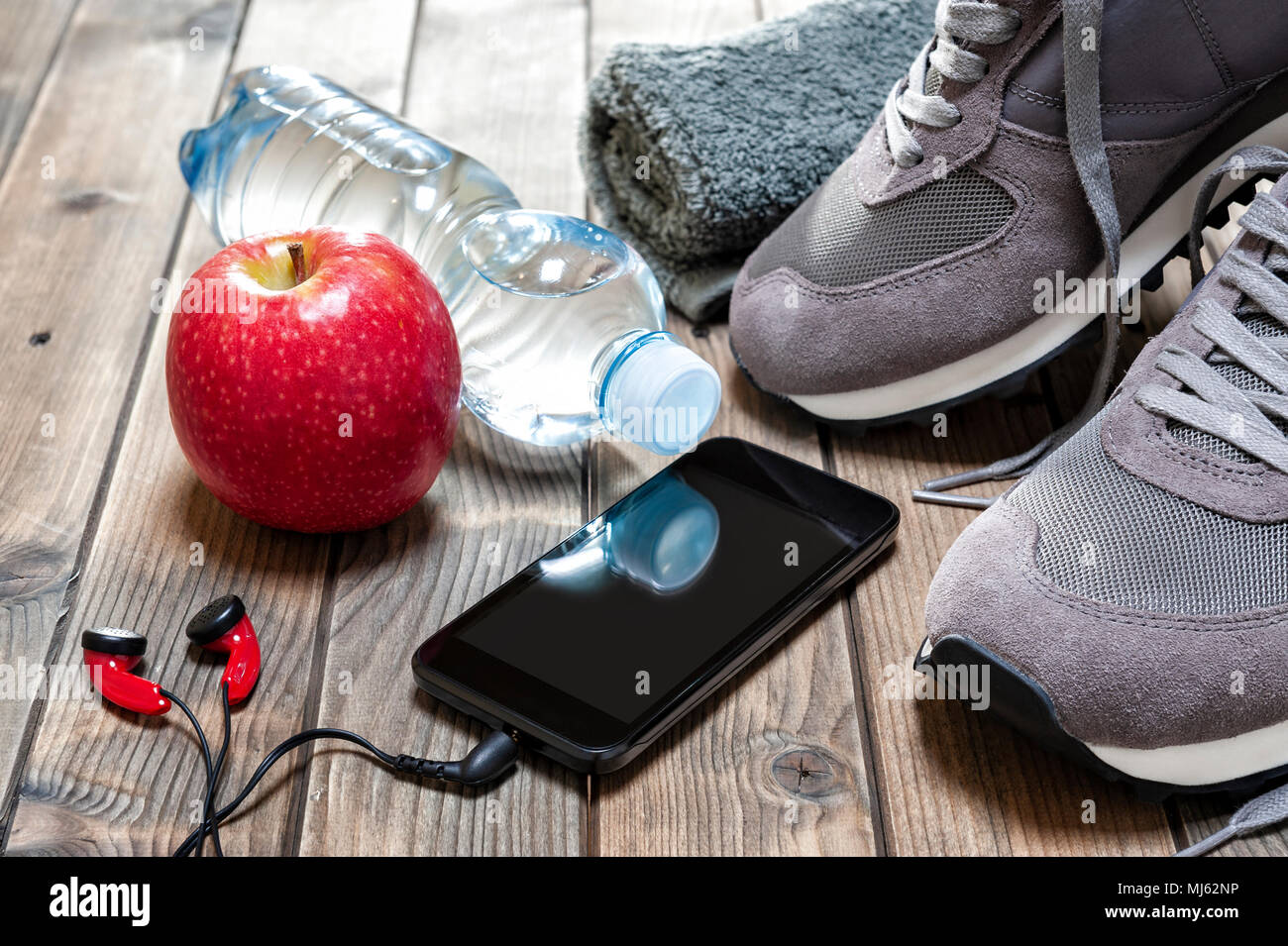 Close-up de una manzana roja, zapatos deportivos, auriculares de audio,  smartphone, toalla y botella de agua fotografiada sobre una mesa de madera  antigua Fotografía de stock - Alamy