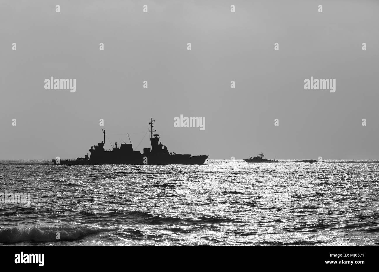 Silueta de un buque de guerra al atardecer en blanco y negro Foto de stock