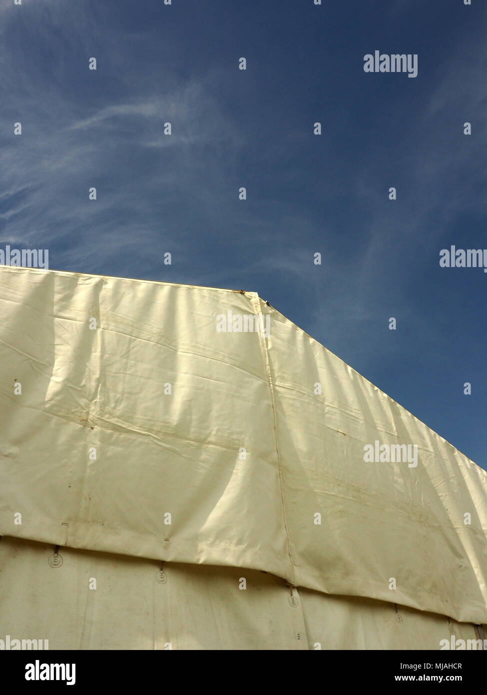 Una desgastada marquesina contra un cielo azul brillante Foto de stock