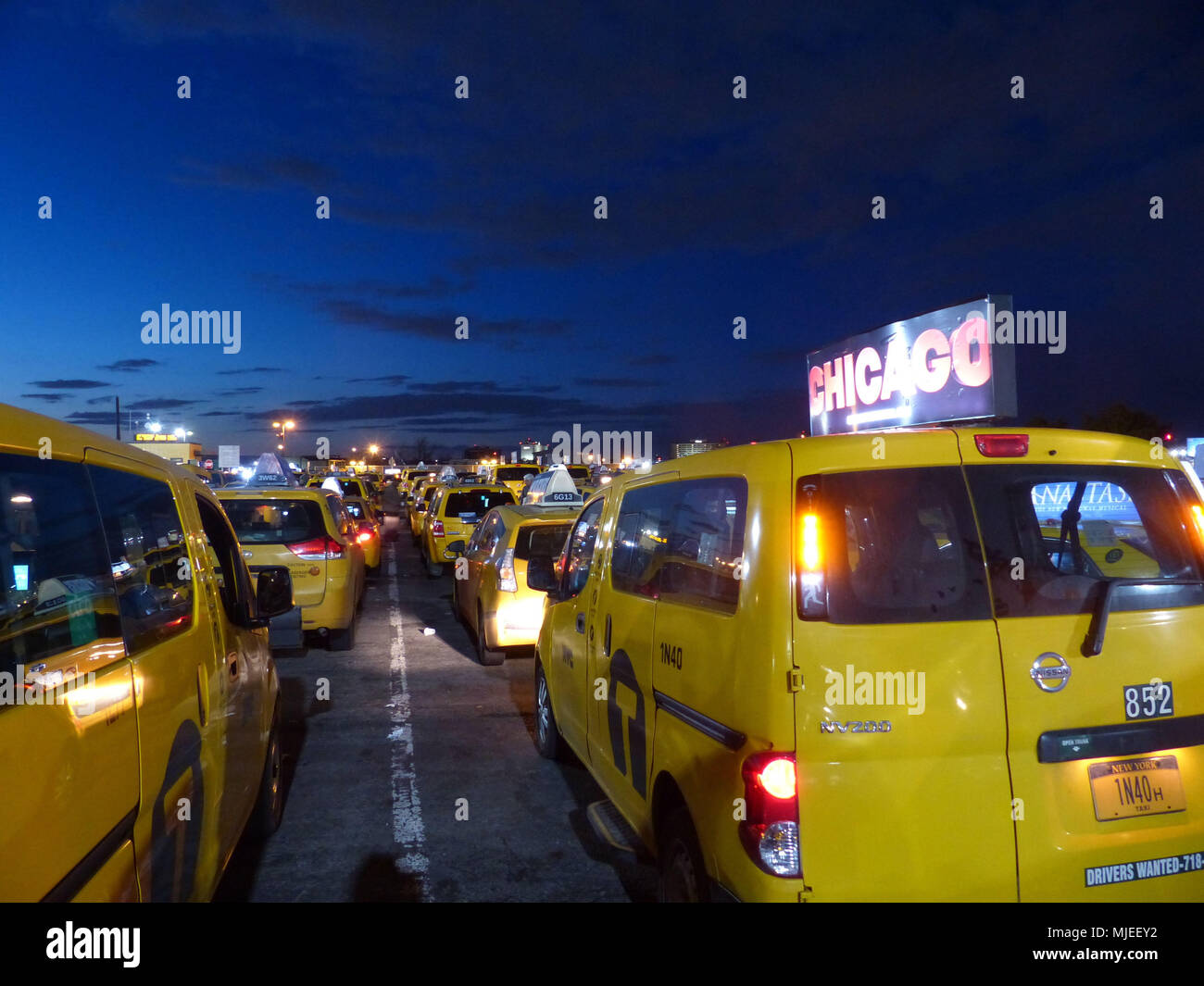 Licencia Yellowcabs por NYC Taxi & Limousine Comisión, espere en el aeropuerto JFK taxi Central espera su turno para recoger a los pasajeros de líneas aéreas Foto de stock
