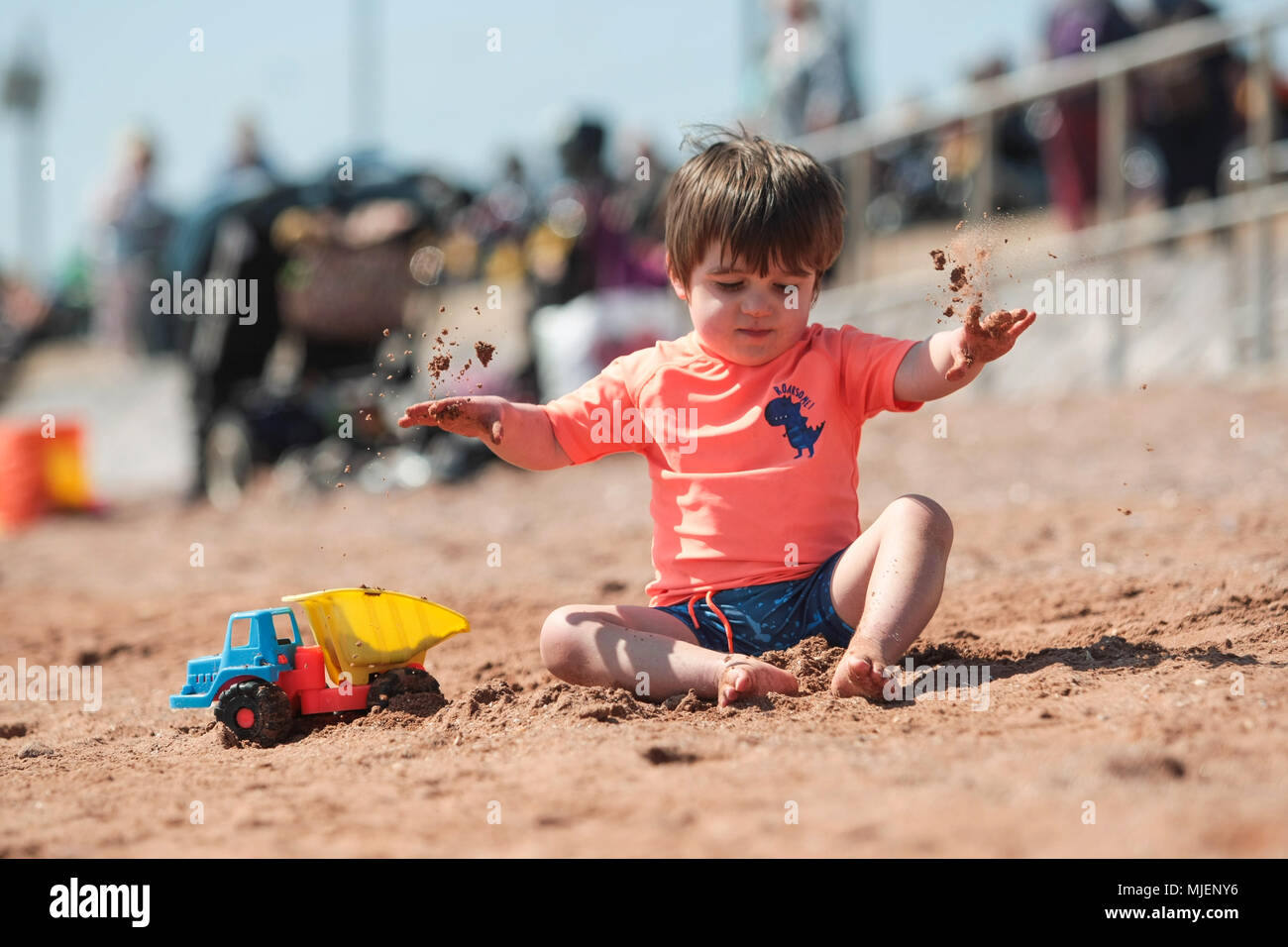 Dos y medio años de edad tiene diversión en Preston playa, Paignton, Devon. Foto de stock