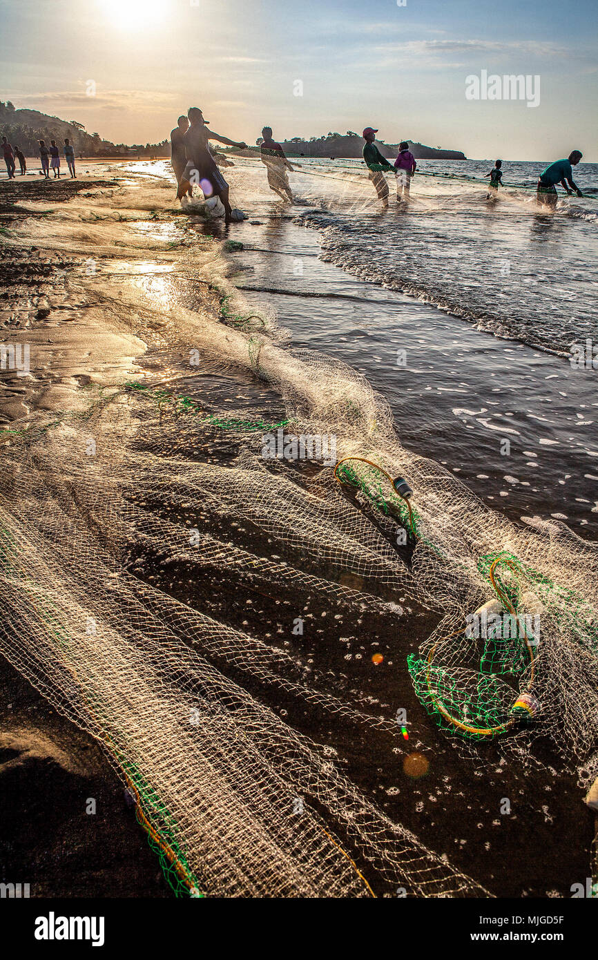 Los pescadores en la playa Baybay peces con un cerco de net en tarde Roxas City, en la isla de Panay, Filipinas. Foto de stock
