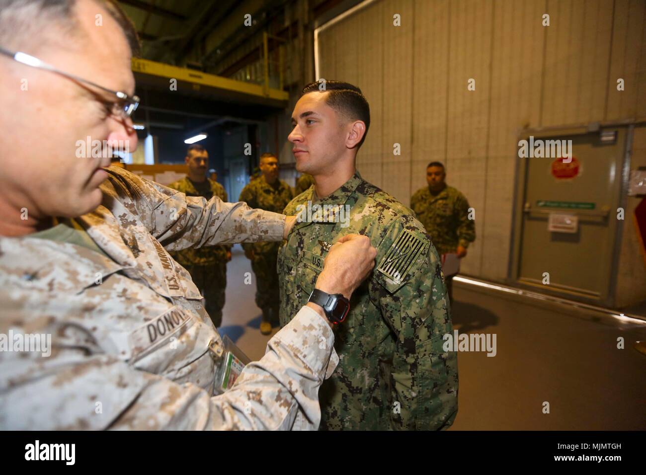 5ª Flota de EE.UU. ZONA DE OPERACIONES (Dec. 13, 2017) - Brig. Gen. Francisco Donovan, comandante general de la Fuerza Naval Anfibia, Task Force 51/5ª Brigada Expedicionaria de la Marina, presenta 3ª clase ayudante médico del Hospital John English, sistema quirúrgico Resuscitative expedicionaria 18, con la guerra de aviación alistado especialista pin durante una breve ceremonia en honor a su logro. Felicitaciones de todos nosotros en el TF 51/5! (Ee.Uu. Foto del Cuerpo de Infantería de Marina por el sargento. Travis Jordan/liberado) Foto de stock