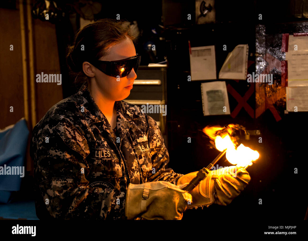 SANTA RITA, Guam (Dec. 8, 2017) Casco Técnico de Mantenimiento de 3ª clase AnnMarie Liles, asignado a la licitación submarino USS Frank Cable (como 40), enciende una antorcha en el tubo tienda a bordo del Submarino USS Emory S. tierras de licitación (39), 8 de diciembre, después de ser nombrado chaqueta azul del año. Liles es deber asignado temporalmente a Emory S. Frank Cable tierra, mientras se encuentra en Portland, Oregon para su dique seco programados de mantenimiento fase de disponibilidad. (Ee.Uu. Navy photo by Mass Communication Specialist 2ª clase Michael Allen McNair/liberado) Foto de stock