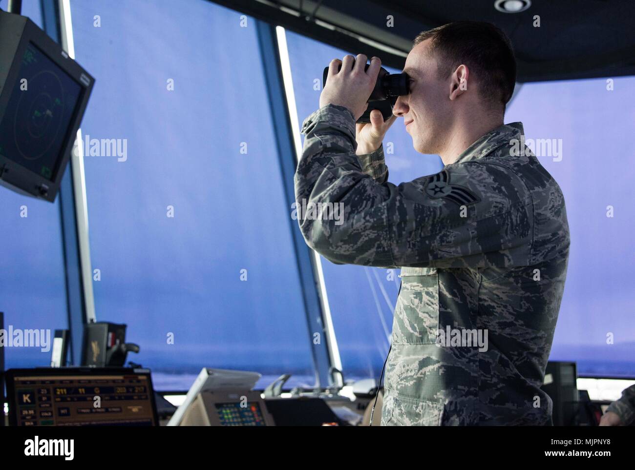 Aviador Senior Brandon Jones, 92ª del Grupo de operaciones de control de  tráfico aéreo aprendiz, utiliza los binoculares para ver la línea de vuelo  el 18 de diciembre, 2017, en la base
