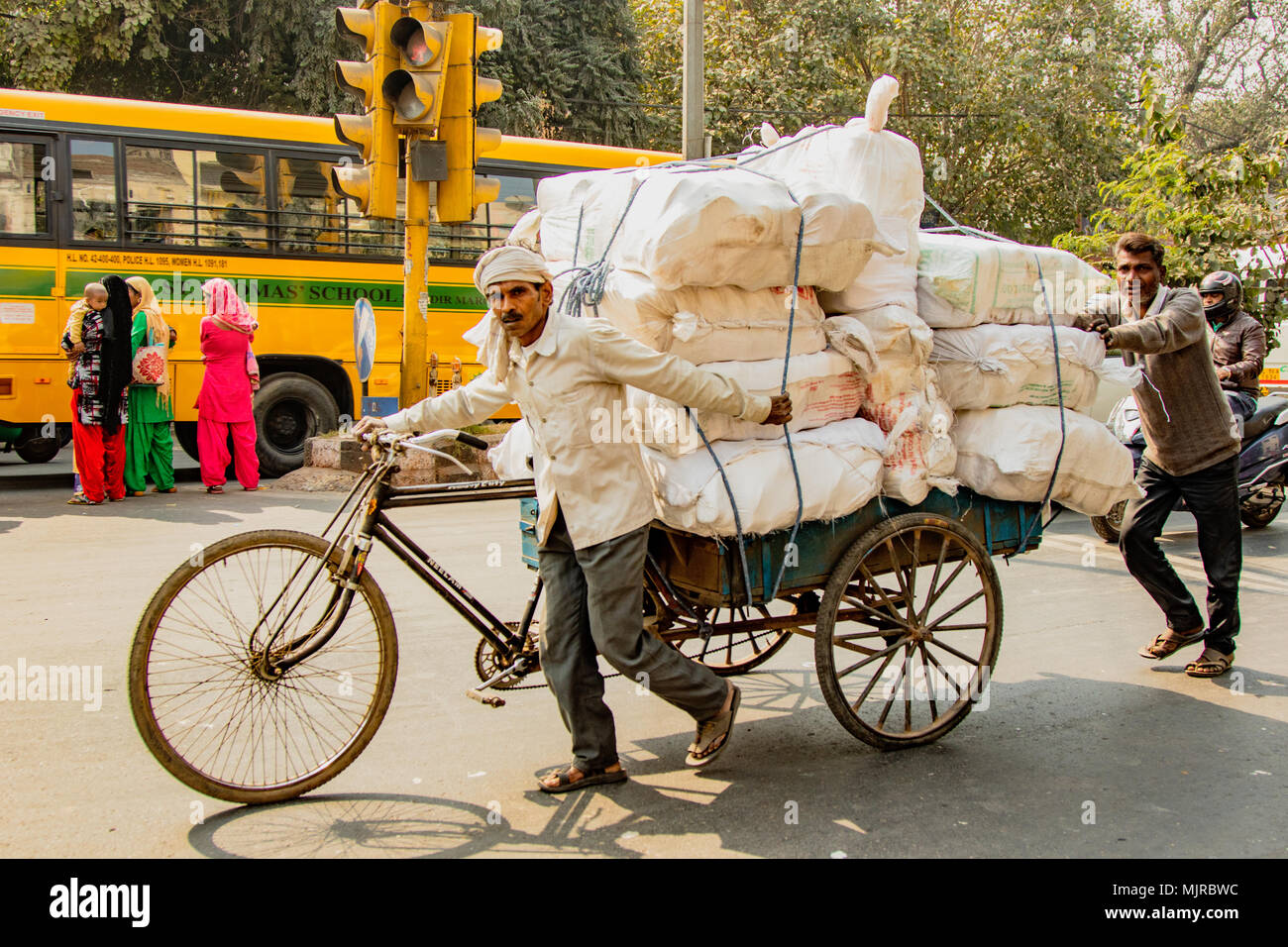 Nueva Dehli, India, Febrero 19, 2018: el hombre lleva carga masiva en  bicicleta en la India Fotografía de stock - Alamy