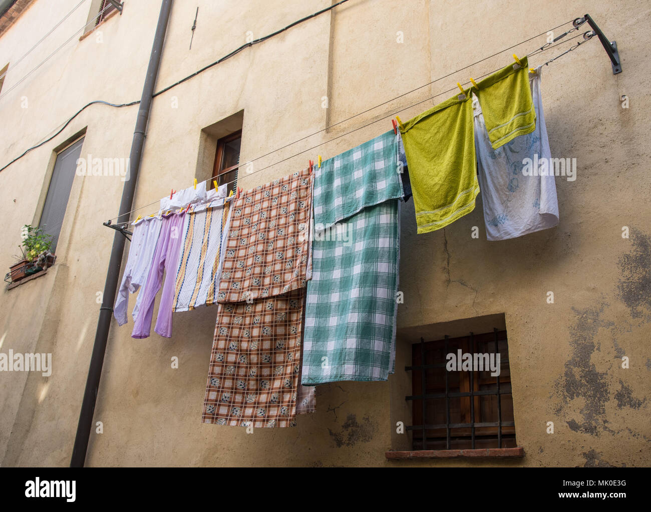 Home Servicio de lavandería con ropa de colores colgando de una cuerda  fuera de una casa para el secado Fotografía de stock - Alamy