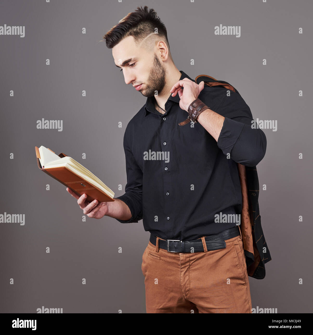 Retrato de dientudo apuesto hombre barbado con el libro en las manos Foto de stock