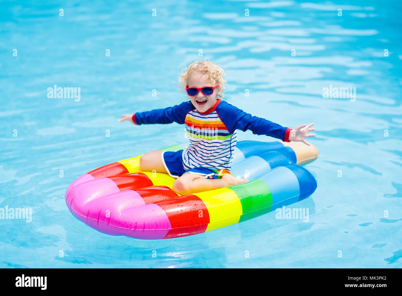 Niño feliz en helados inflables flotar en la piscina exterior del complejo  tropical. Vacaciones de verano con niños. Nadar y desgaste del SIDA para  los niños. Wat Fotografía de stock - Alamy