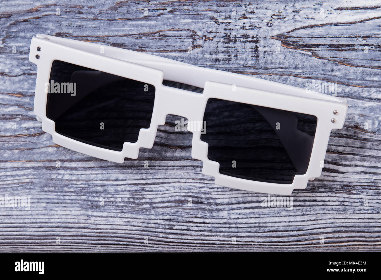 Gafas de sol de píxeles cercanos. Black anteojos con marco blanco sobre un  mostrador de madera de la superficie Fotografía de stock - Alamy