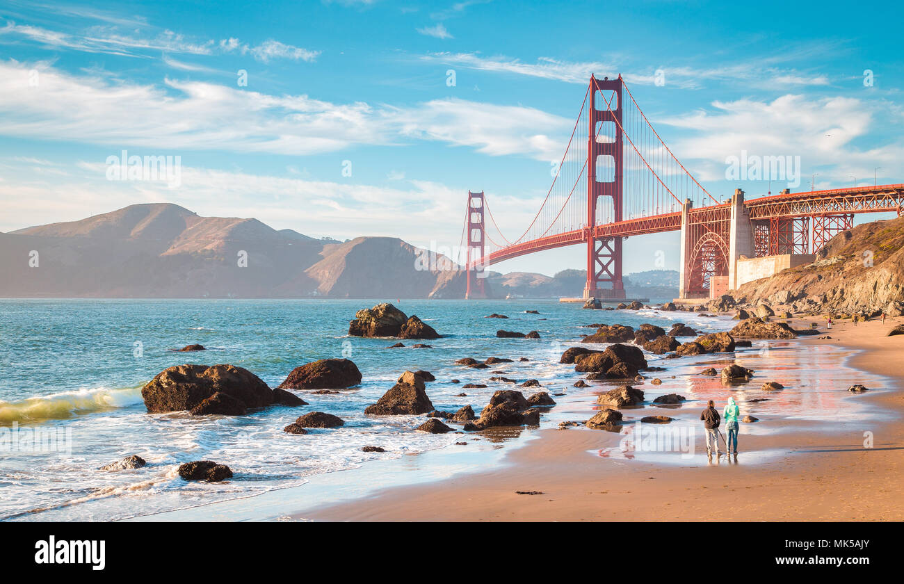 Classic vista panorámica del famoso Golden Gate Bridge visto desde el escénico Baker en la hermosa playa dorada luz del atardecer en un día soleado con el cielo azul y cl Foto de stock