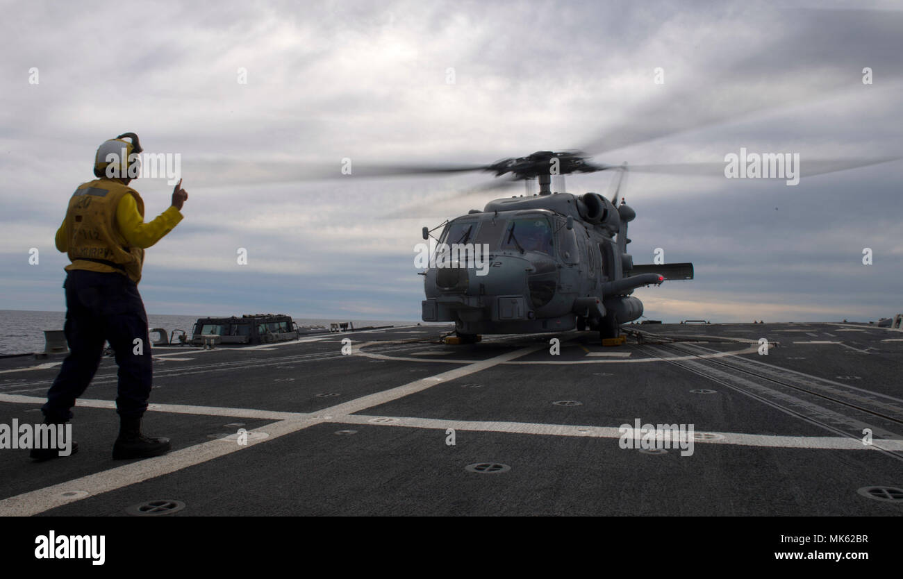 171108-N-LN093-0187 OCÉANO PACÍFICO (Nov. 8, 2017) Boatswain's Mate de 2ª clase de Brittany Chiles señala un MH-60R Sea Hawk de los "halcones" azul huelga marítimo escuadrón de helicópteros (HSM) 78 en la cubierta de vuelo del misil guiado por Burke-Class Arleigh destructor USS Wayne E. Meyer (DDG 108). Michael Murphy está participando en un ejercicio de capacitación logística en preparación para una futura implementación. (Ee.Uu. Navy photo by Mass Communication Specialist Seaman Jasen Morenogarcia/liberado) Foto de stock