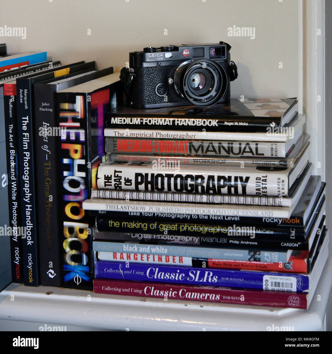 Cámara de telémetro Leica M6 sobre el montón de libros de fotografía sobre mantlepiece Foto de stock