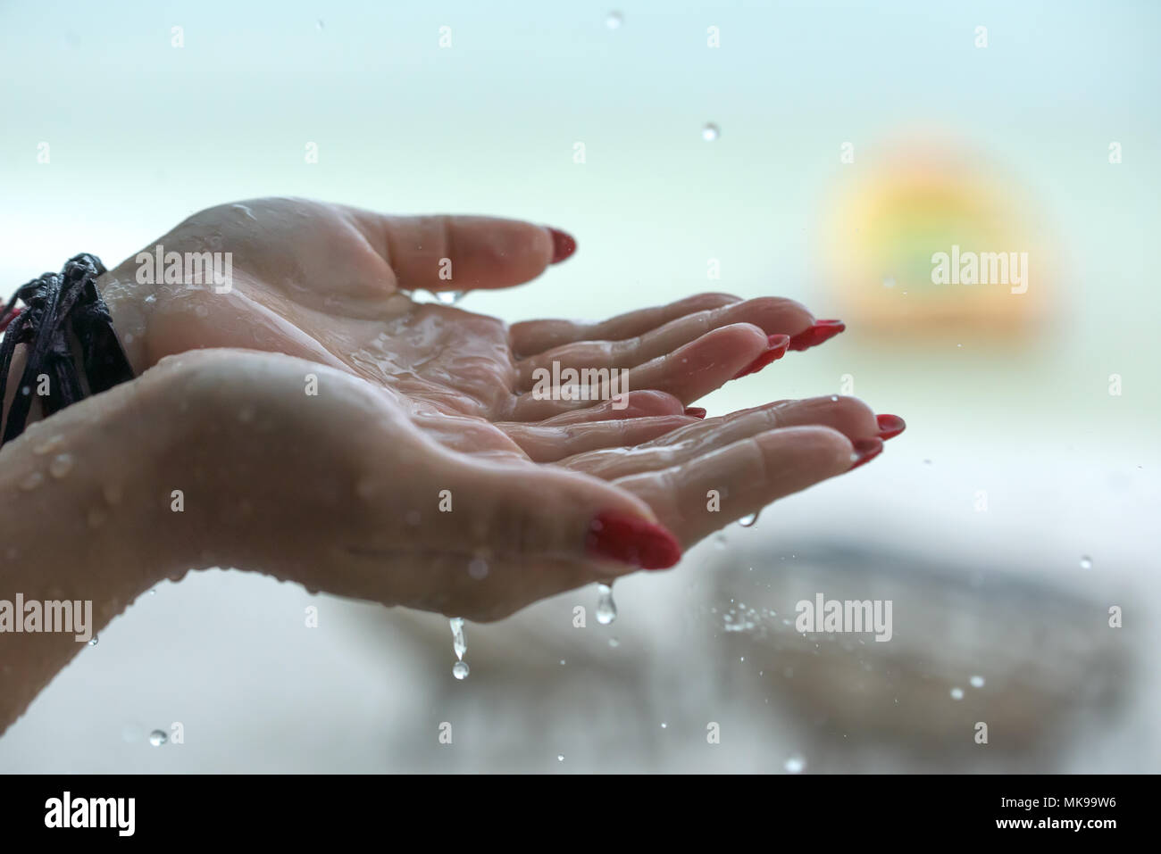 Las gotas de lluvia cayendo en manos de mujer Fotografía de stock - Alamy