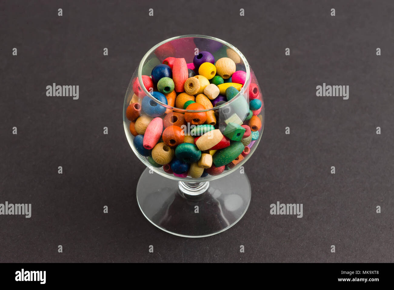 Un vaso de perlas multicolores de diferentes formas y tamaños, utilizado para crear joyas Foto de stock
