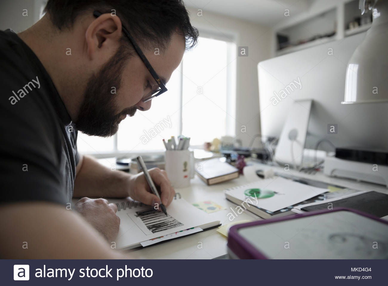 Centrado masculino boceto de Illustrator en la oficina principal Foto de stock