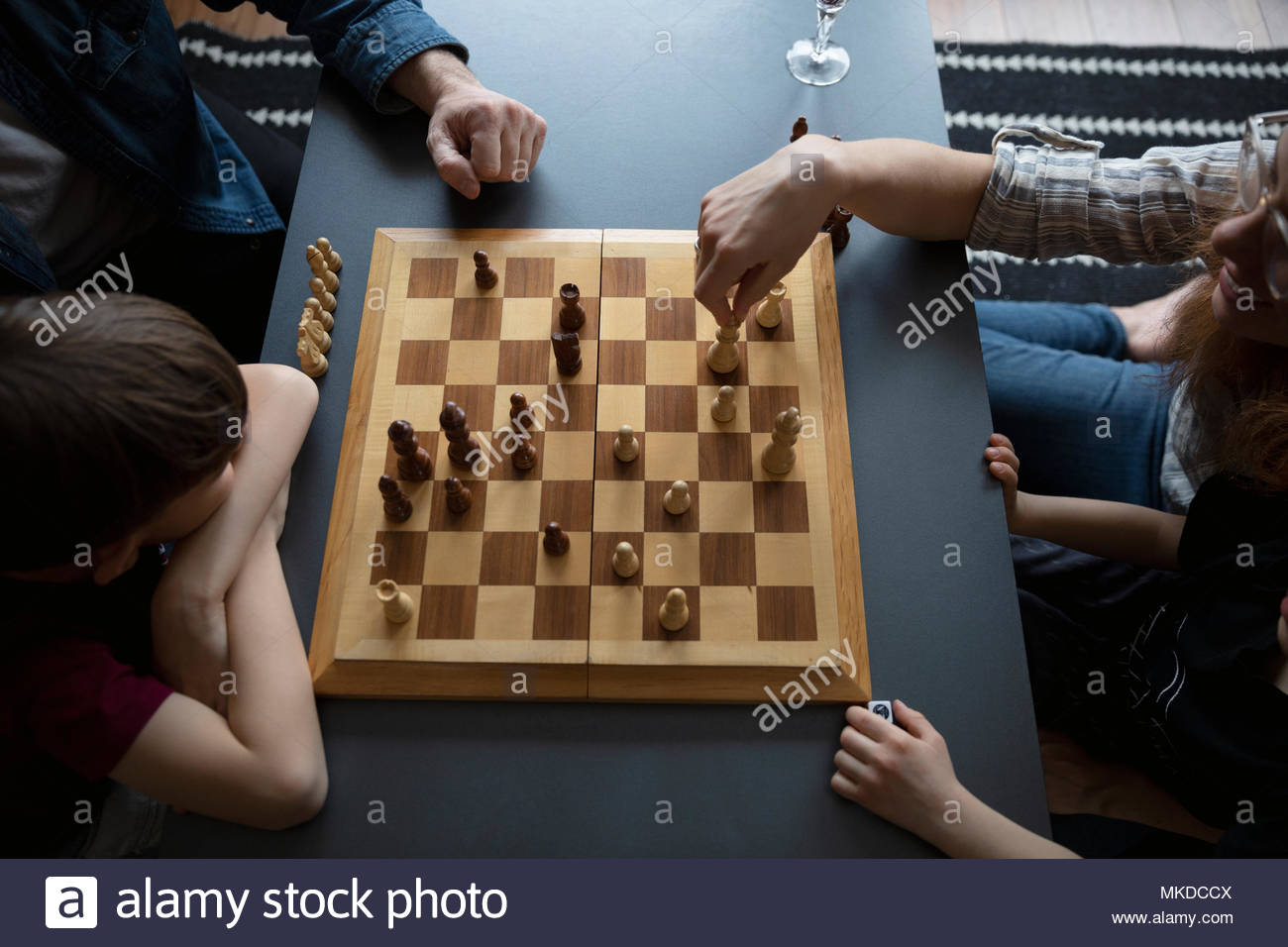 Vista aérea familia jugando ajedrez en mesa de café Foto de stock