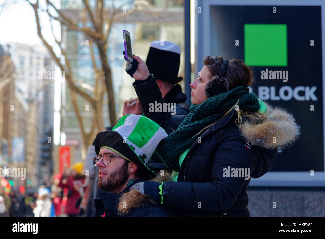 Una joven mujer filmando los Montreal desfile del Día de San Patricio Foto de stock