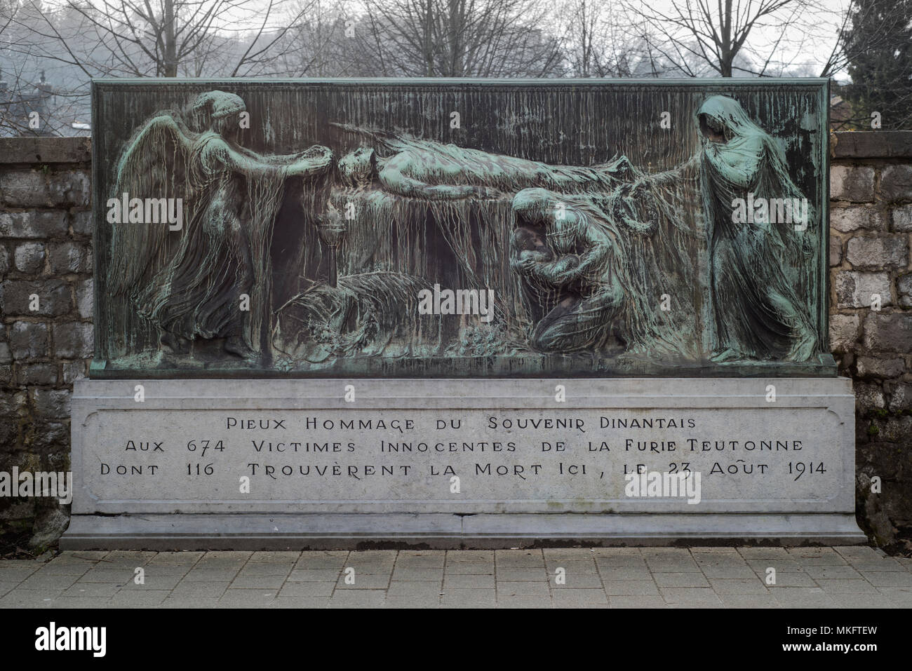 War Memorial de 116 civiles muertos a tiros en la pared Mur Tschoffen, alivio de bronce, el pedestal con la inscripción, la masacre de Dinant Foto de stock