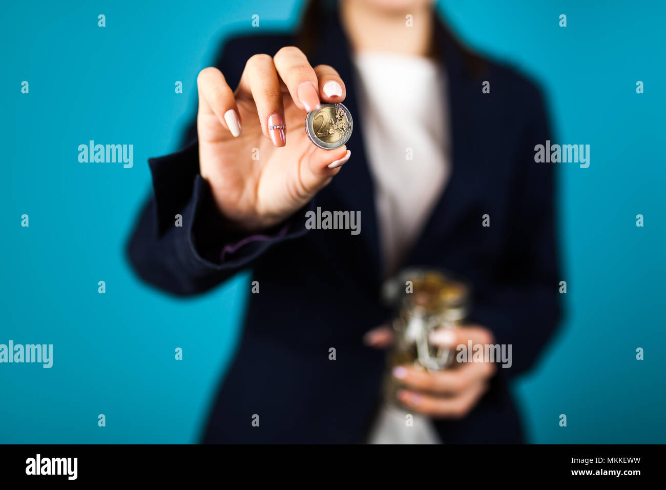 Mujer sosteniendo una moneda de 2 Euros Foto de stock