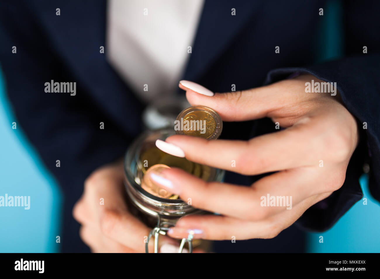 Mujer sosteniendo una moneda de 2 Euros Foto de stock