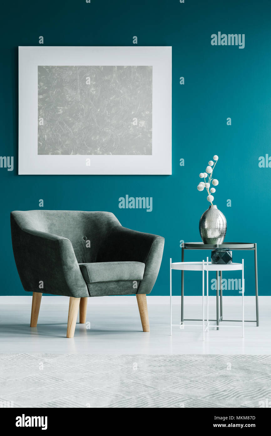 Pintura sobre una pared de color turquesa, gris sillón y mesas laterales en  una sala de espera interior Fotografía de stock - Alamy