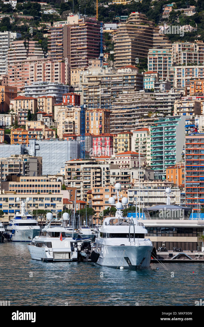 Principado de Mónaco desde el puerto, edificios de apartamentos, bloques de pisos, casas en una empinada ladera de montaña costera Foto de stock