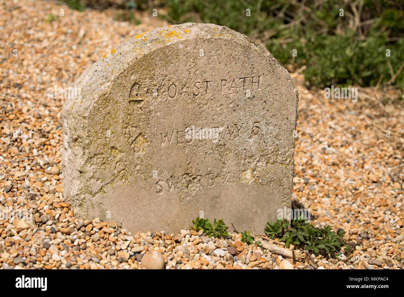 Una piedra cerca de West Bexington marcador de distancia a lo largo de un sendero detrás de Cesil beach en Dorset, Inglaterra indicando una distancia de 5 millas al oeste de la bahía. Foto de stock
