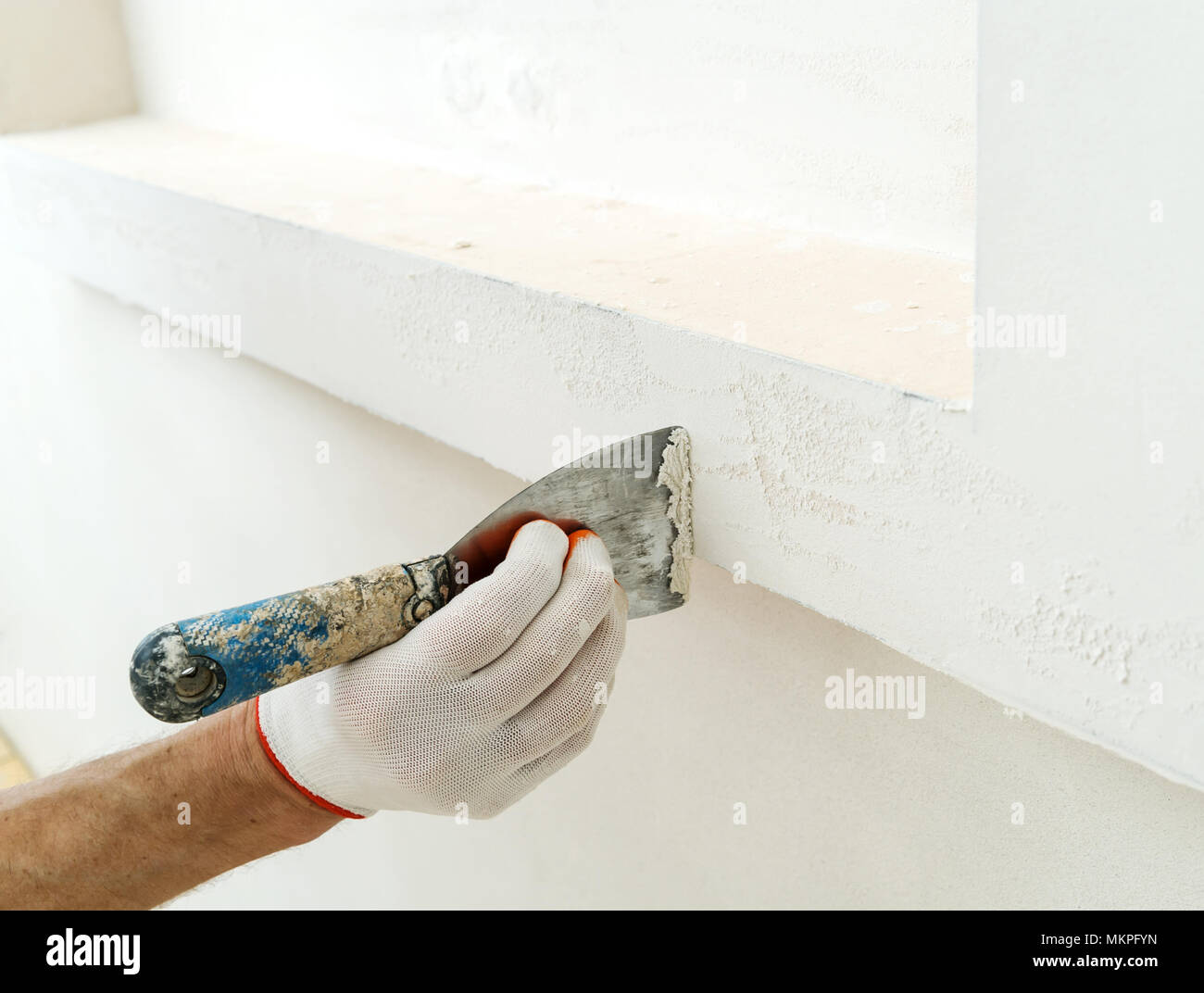 Revestimiento de yeso decorativo. El hombre tiene la textura irregular en  la pared con una espátula Fotografía de stock - Alamy