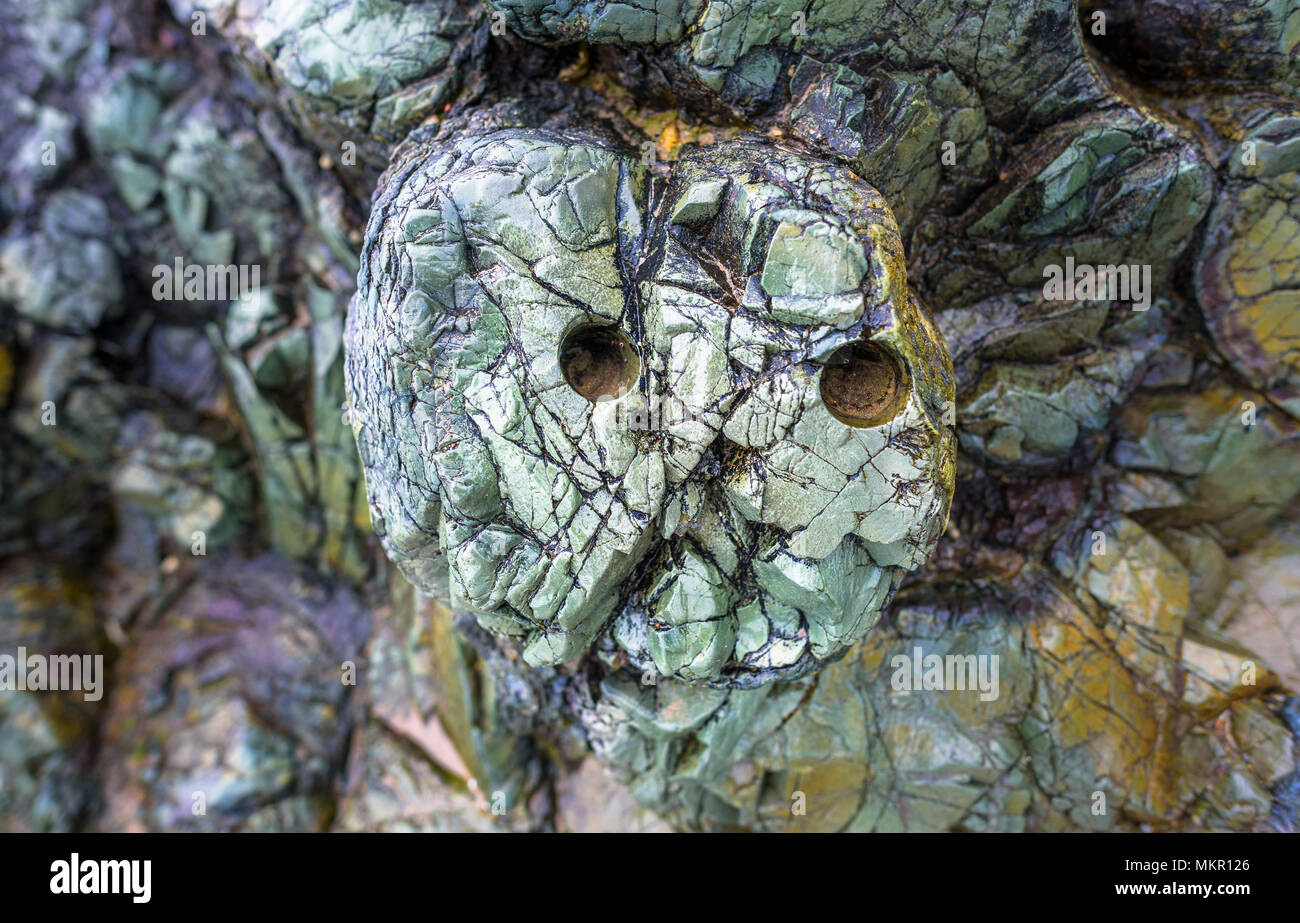 Resumen espeluznante rostro fantasmal en una formación de roca volcánica. Foto de stock