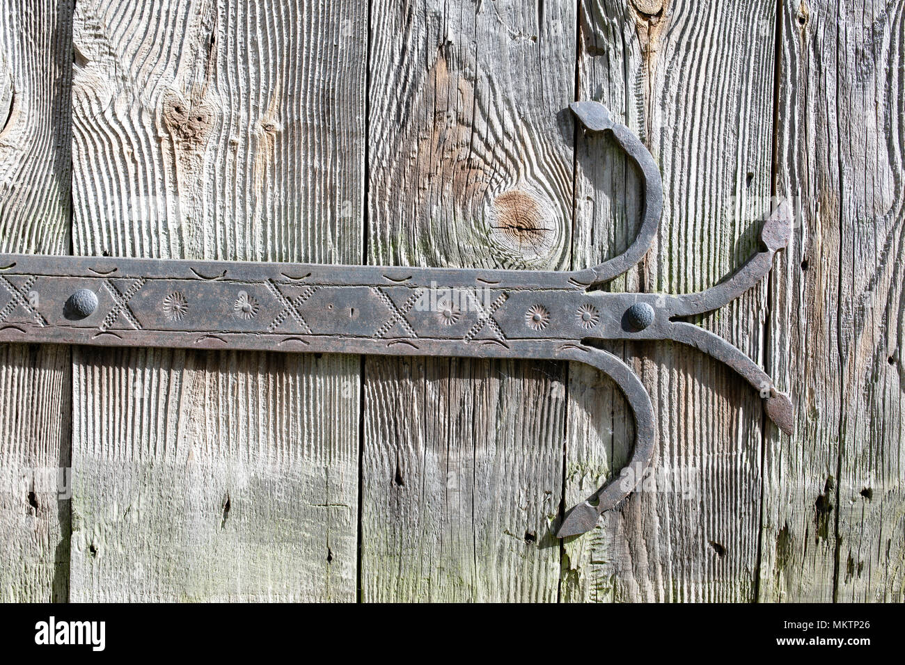 Una puerta con bisagras de hierro forjado ornamental, antiguas, vintage  golpeando la puerta de madera. Detalle Fotografía de stock - Alamy