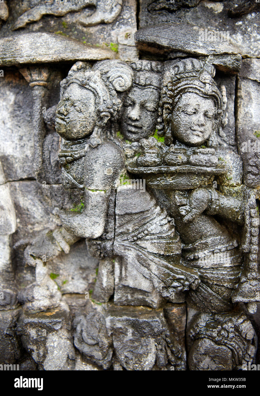 Tres figuras en bajorrelieve de piedra tallada del siglo ix templo Budista Borobudur Java Indonesia Foto de stock
