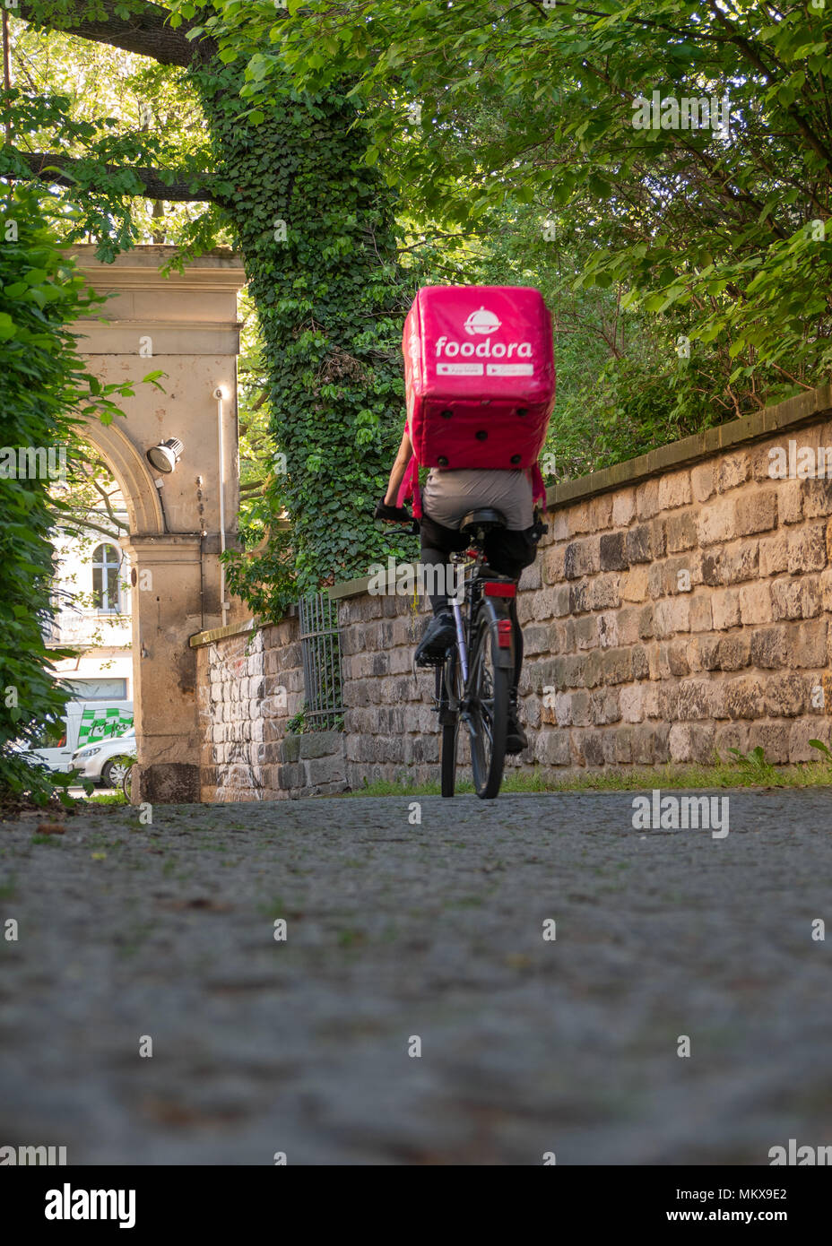 Dresden, Alemania: el servicio de entrega de alimentos. Una hembra foodora courier en su camino hacia el próximo restaurante. Foto de stock
