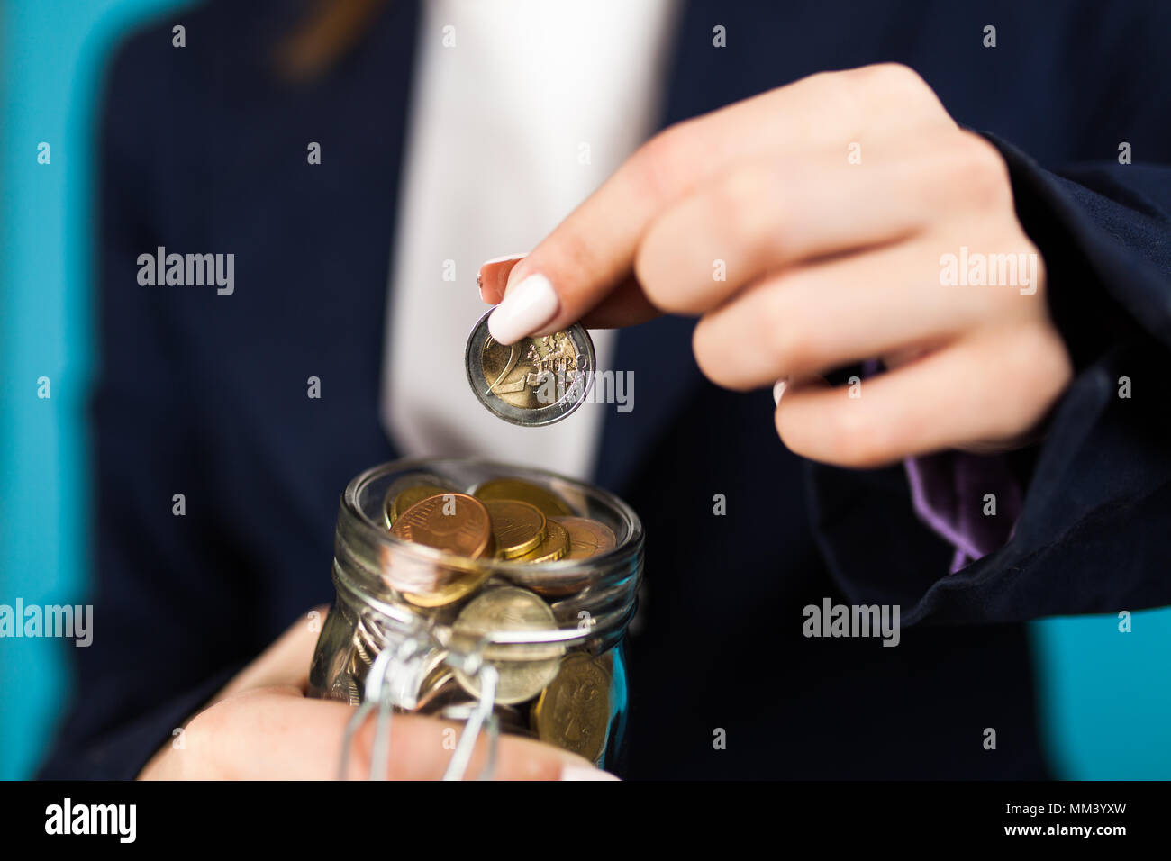 Mujer sosteniendo una moneda de 2 Euros Foto de stock