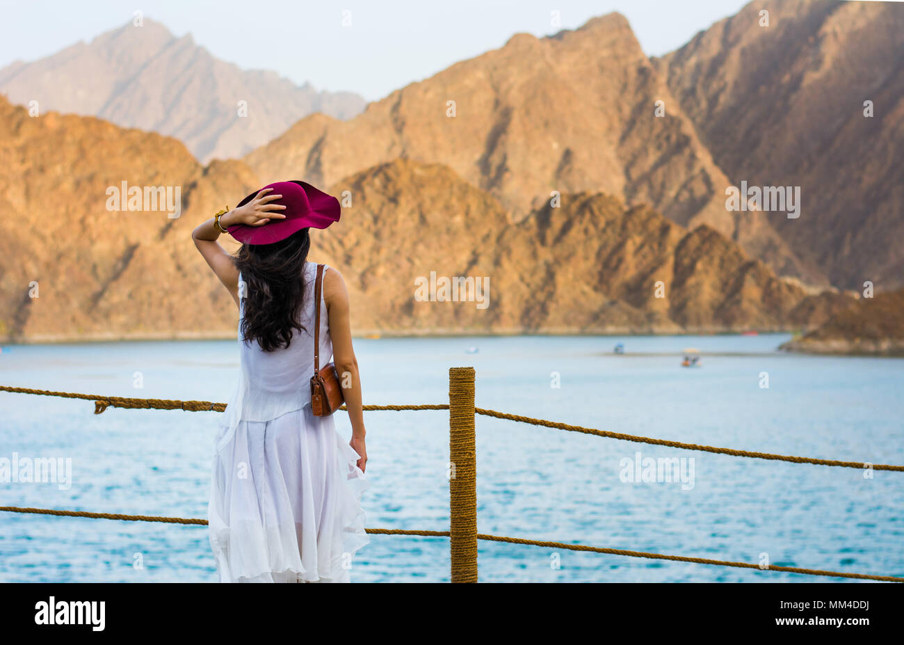 Mujer disfrutando del paisaje del lago Embalse Hatta en la región oriental de Dubai, Emiratos Árabes Unidos. Foto de stock