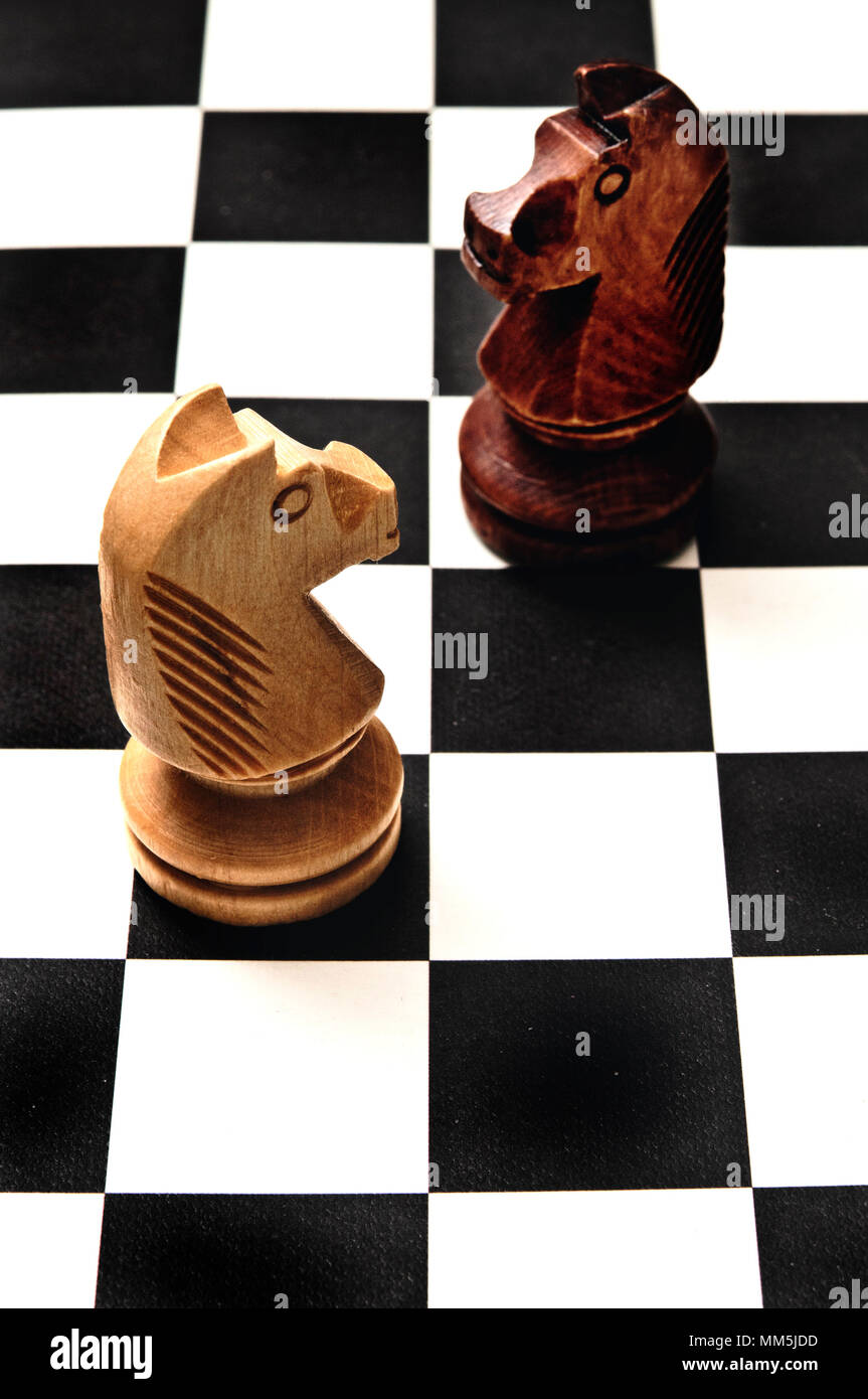 Dos caballeros de ajedrez en el tablero de ajedrez, que se enfrentan entre sí. Reto o decisiones concepto Foto de stock