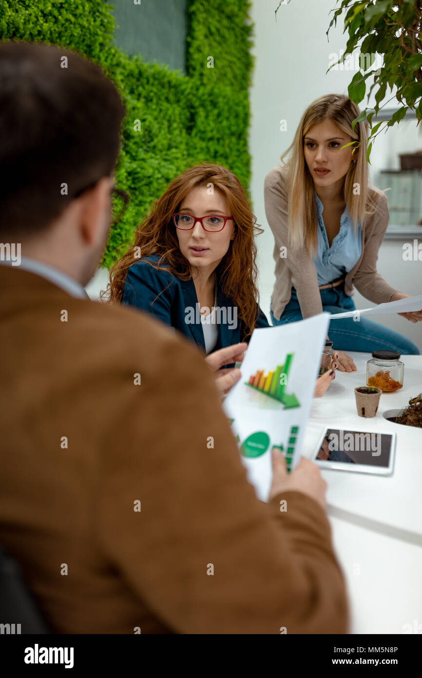 Los gerentes de negocios jóvenes tripulantes trabajando con el nuevo proyecto de inicio y analizar planes de gráfico. Foto de stock