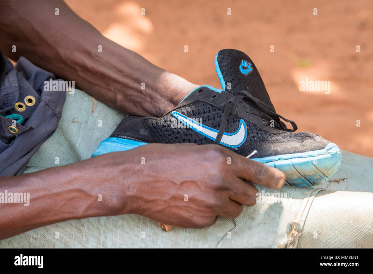 Zambiano limpieza de uno de sus zapatos Nike Running, aldea Mukuni, Zambia  Fotografía de stock - Alamy