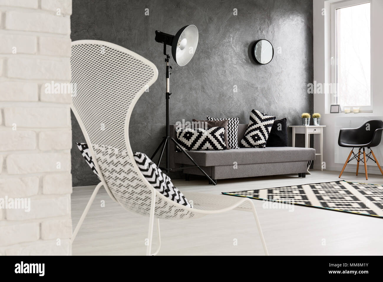 Gris sala de sofá, sillas, una lámpara de pie, de ladrillo y decoraciones en blanco y negro Fotografía de stock -