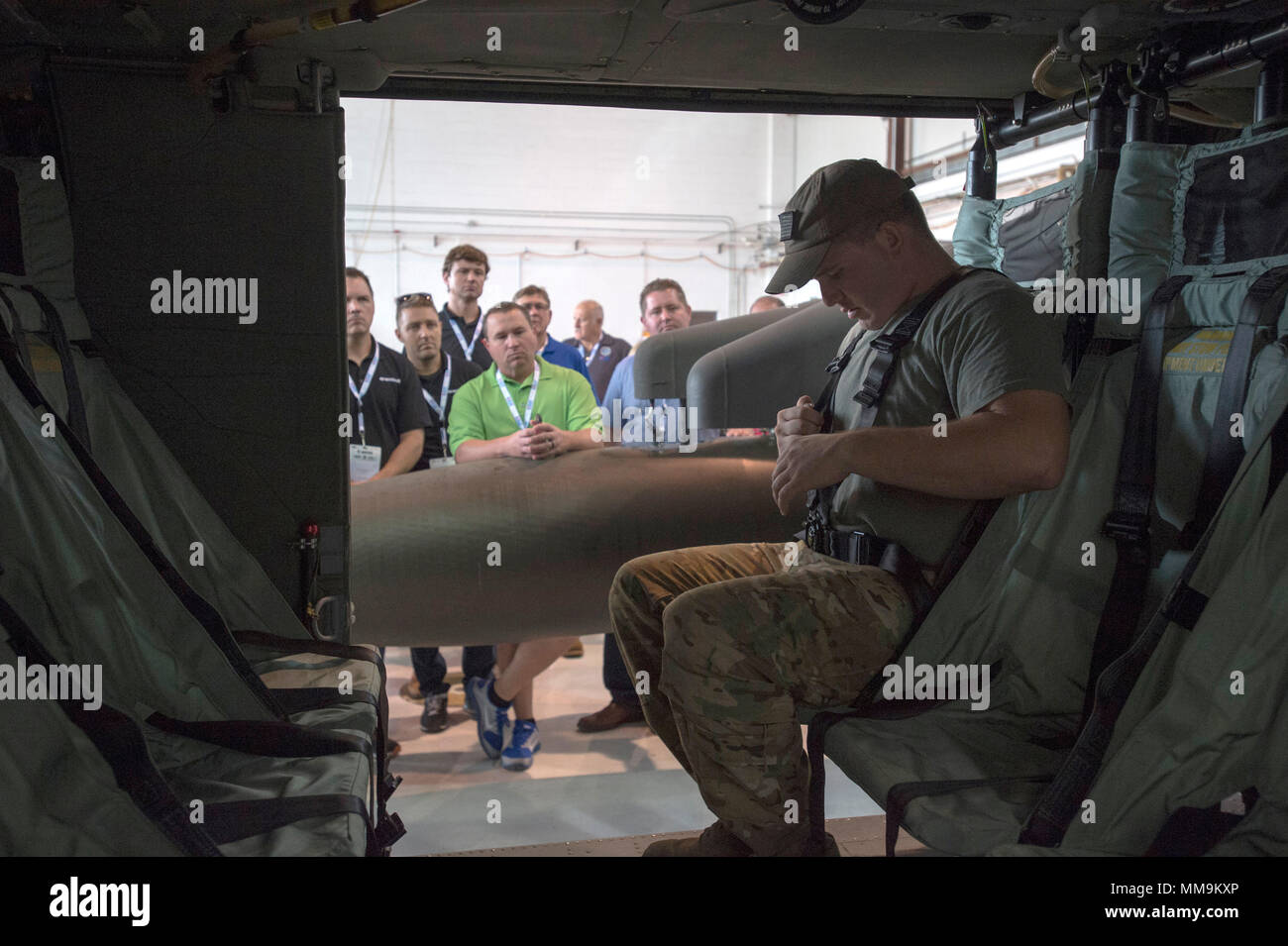 El sargento jefe de la tripulación de la aviación. Anthony Delmedico  muestra la forma correcta de usar el arnés de seguridad en el helicóptero  UH-60 Blackhawk, un grupo de empleadores en la