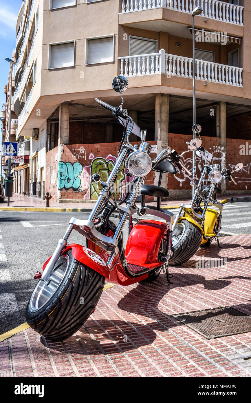Alquiler de Scooter eléctrico. Alquilar CB scooter moto. Brillantes colores  bicicletas eléctricas en las calles de Guardamar, España. Español ciudad  Med Fotografía de stock - Alamy