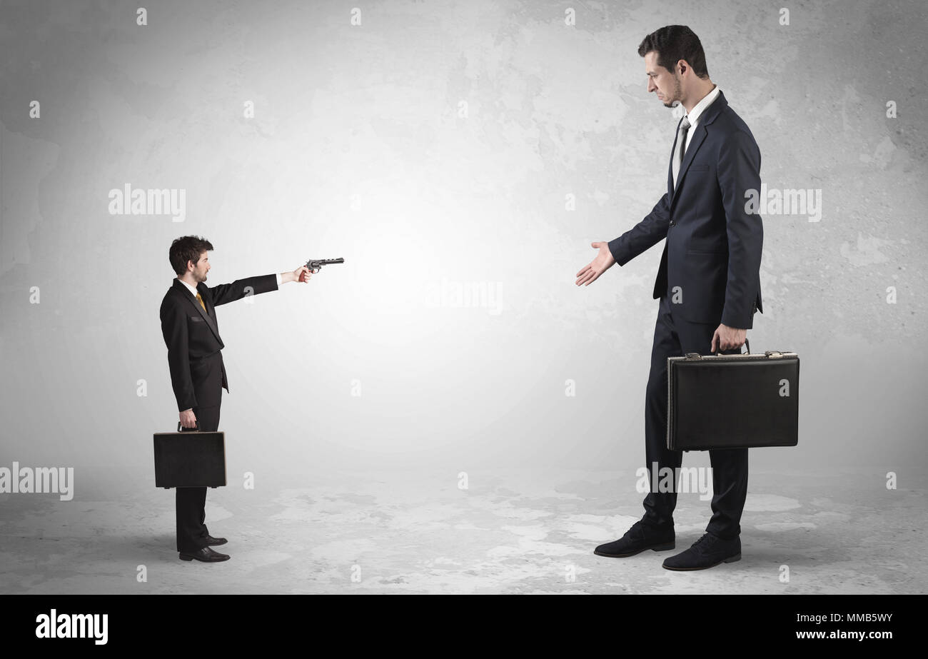 Pequeño empresario con tiroteos gigante empresario temeroso Foto de stock