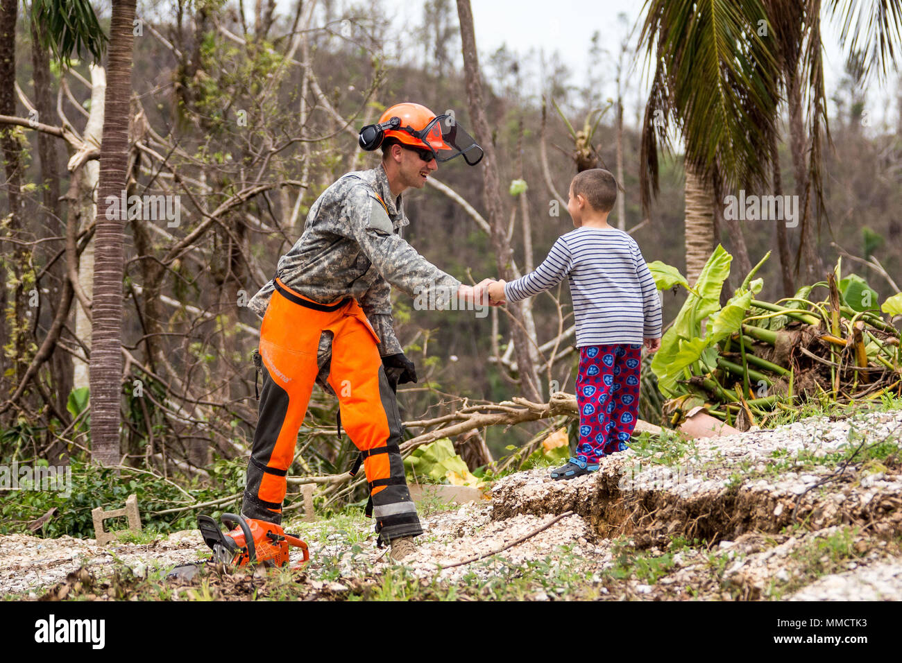 Spc. Raymond de Townville Avery, Carolina del Sur, toma un descanso en la  limpieza de carreteras en Puerto Rico para decir hola a un joven en las  inmediaciones de Cayey. Avery, quien