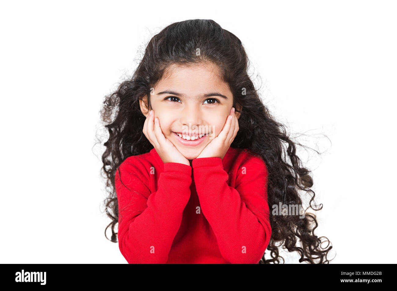 Un niño niña sonriente con la mano en el mentón Looking-Away inclinada disfrutando Foto de stock