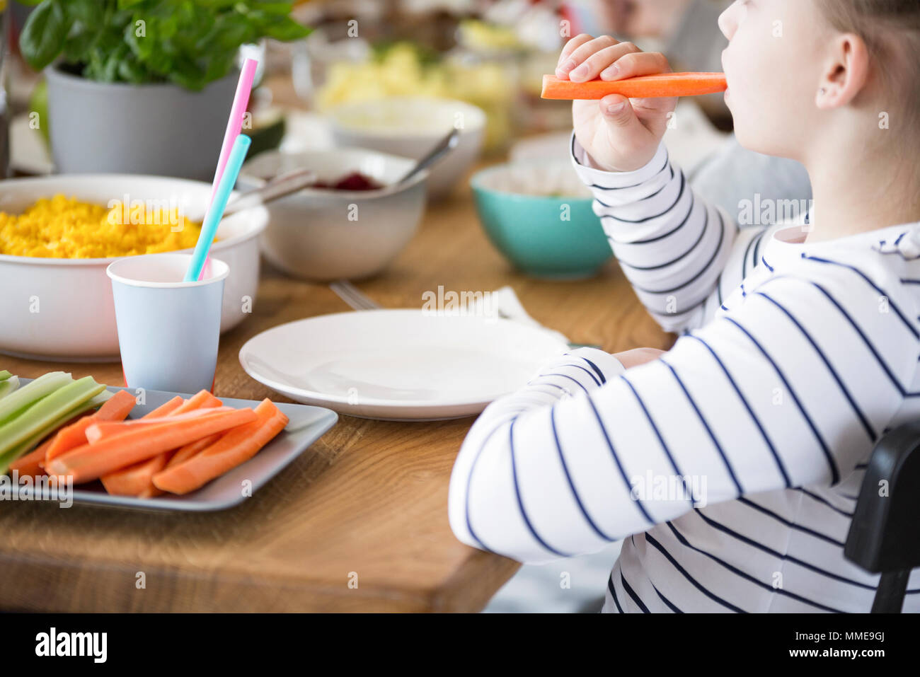 Close-up de kid comer zanahorias durante el desayuno. Dieta saludable para los niños concepto Foto de stock