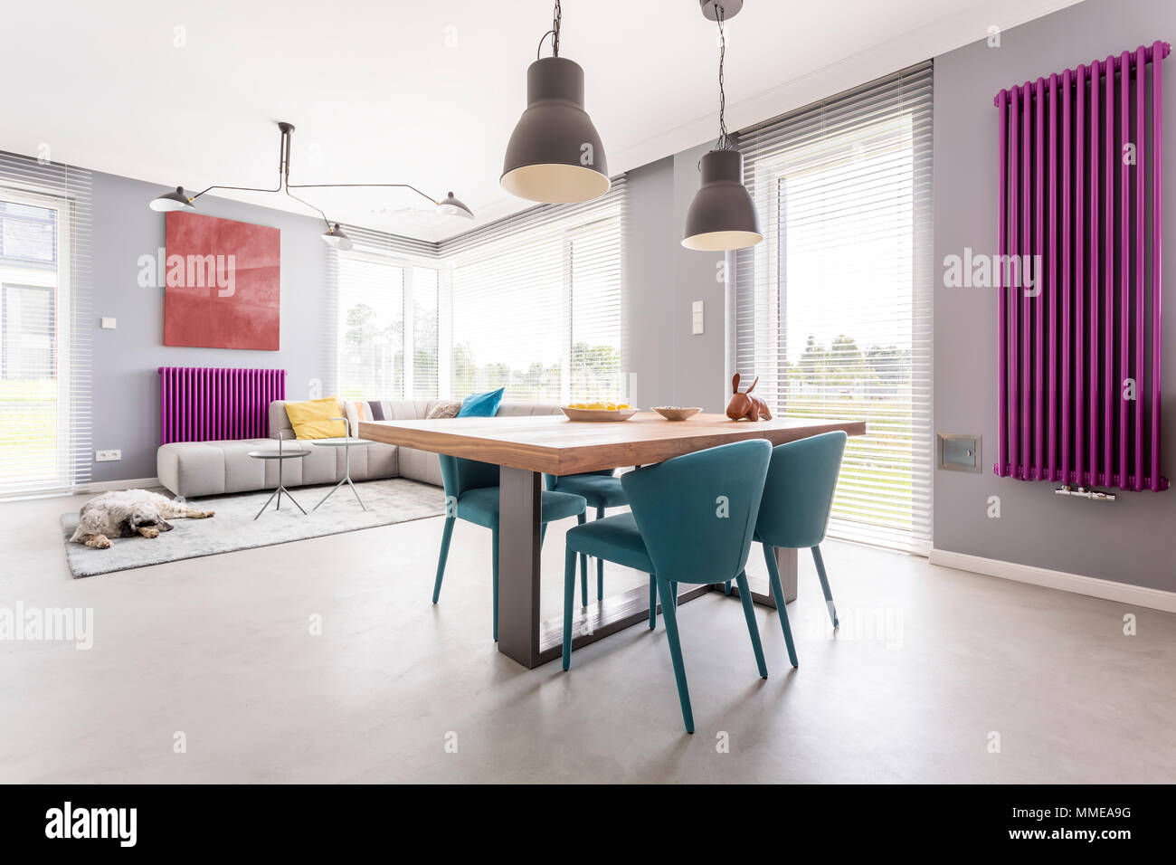 Moderno interior de comedor y sala de estar de planta abierta con grandes  ventanales, ilustraciones y coloridos accesorios Fotografía de stock - Alamy
