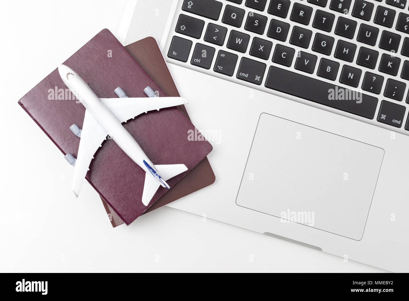 Pasaporte , blanco modelo de avión y el ordenador portátil sobre fondo blanco . Viajes , visa y concepto de vacaciones Foto de stock