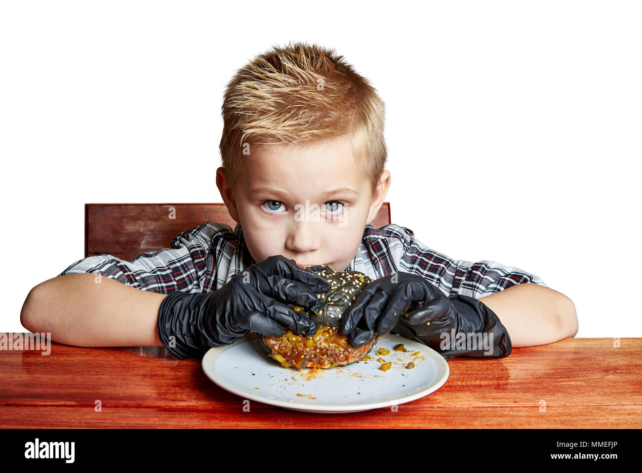 Un niño usando guantes negros que come una hamburguesa negro Fotografía de  stock - Alamy