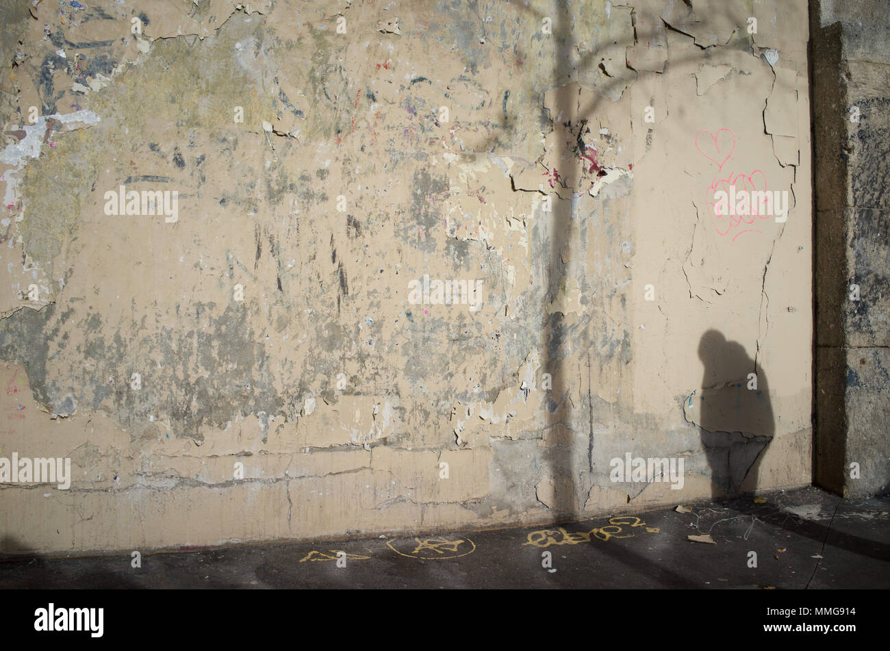 Sombra del hombre encorvado y árbol en la pared (en mal estado), Rue De Clignancourt, 75018 París, Francia Foto de stock