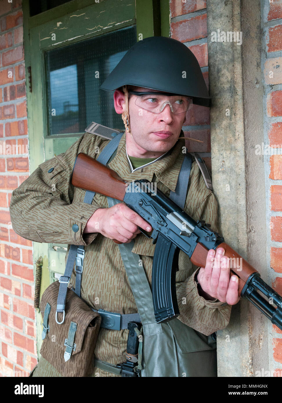 Un airsoft jugador lleva medio alemán, 1975, Junior Suboficiales uniforme  con un rifle de asalto automático AK-47, el Kalashnikov Fotografía de stock  - Alamy